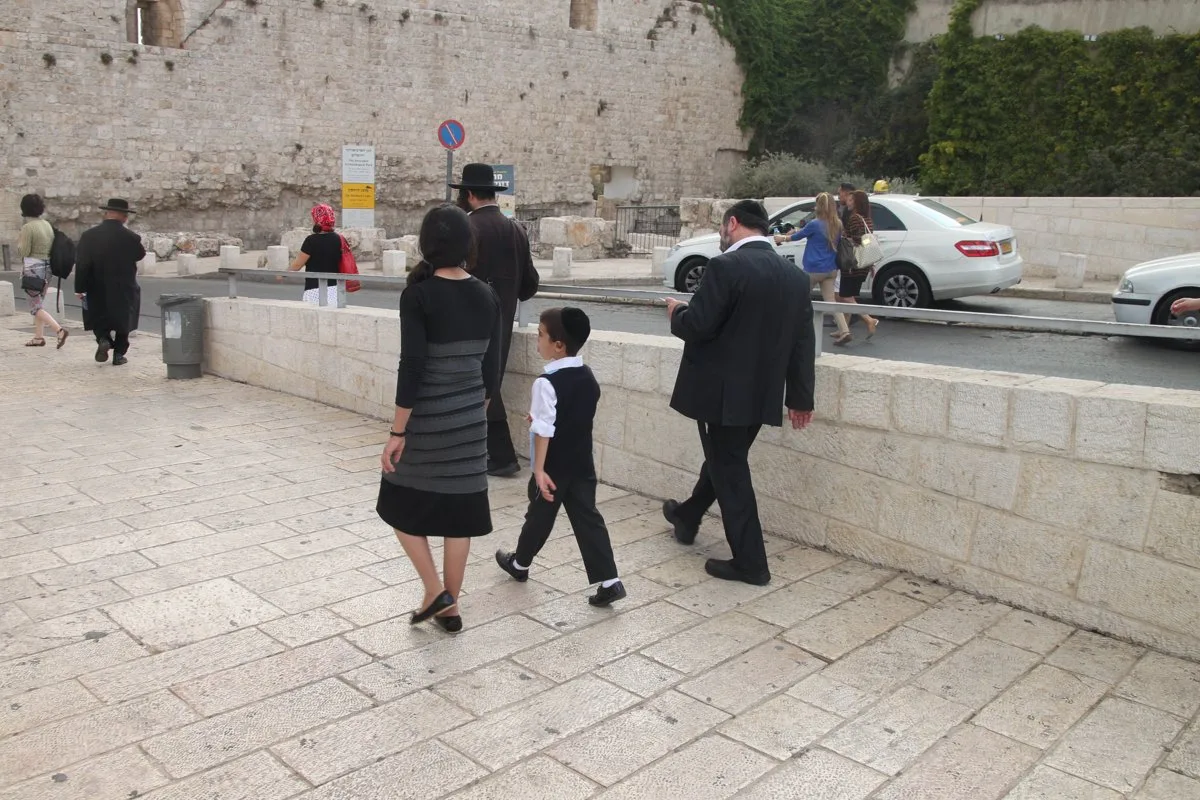 A large group walking through a street in Jerusalem's Old City