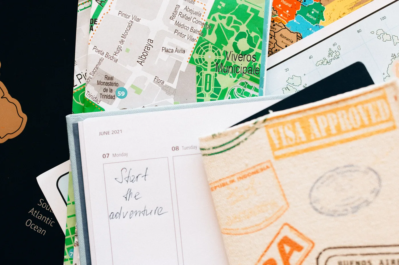 A guide's notebook, map and travel documents laid out for trip planning