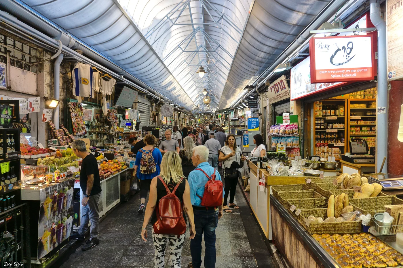 A narrow covered alley lined with stalls in Jerusalem's Mahane Yehuda market