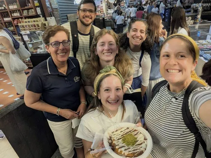 Tourists sharing a plate of knafeh on a Mahane Yehuda food tour